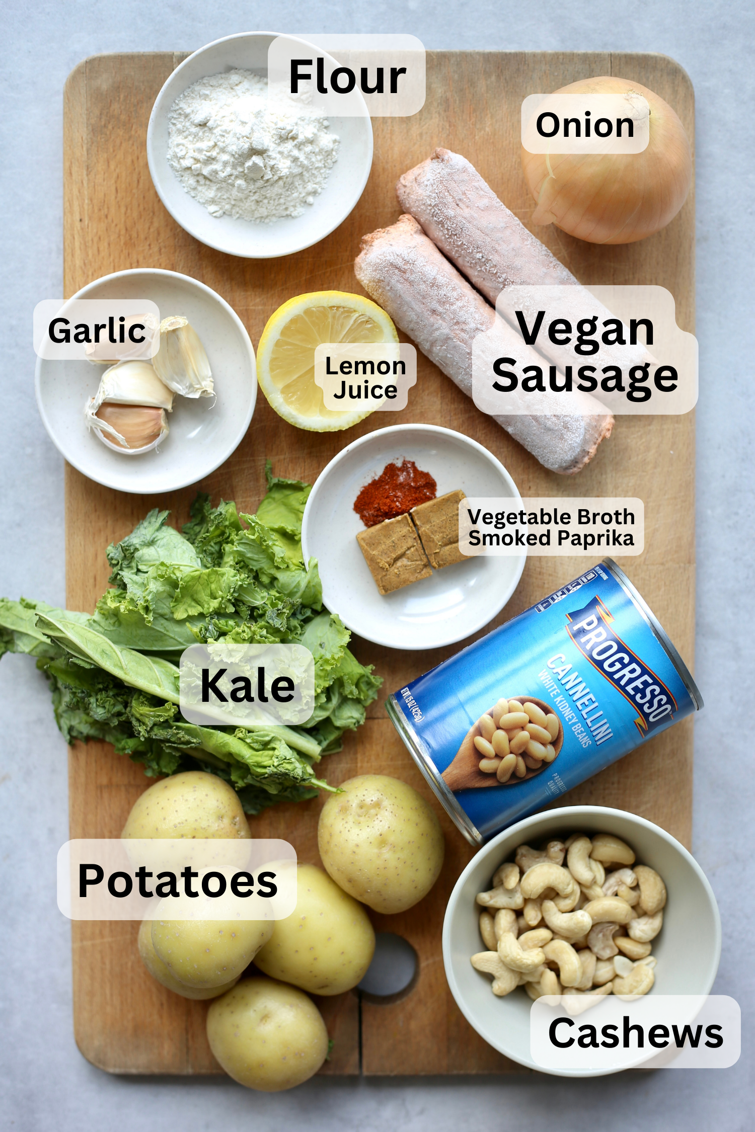 All of the ingredients for zuppa toscana measured out into bowls on a wooden cutting board. 