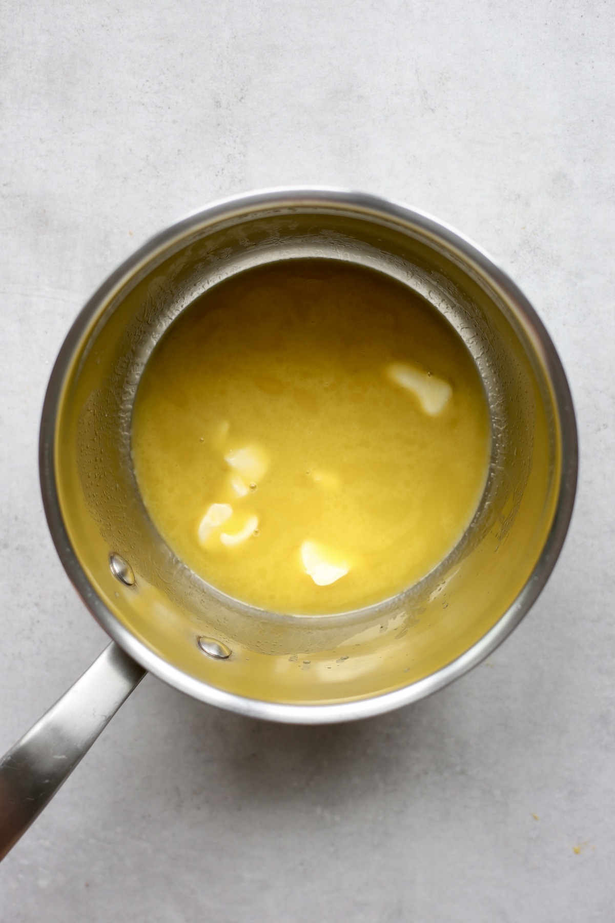 Vegan butter melting in a silver saucpan.