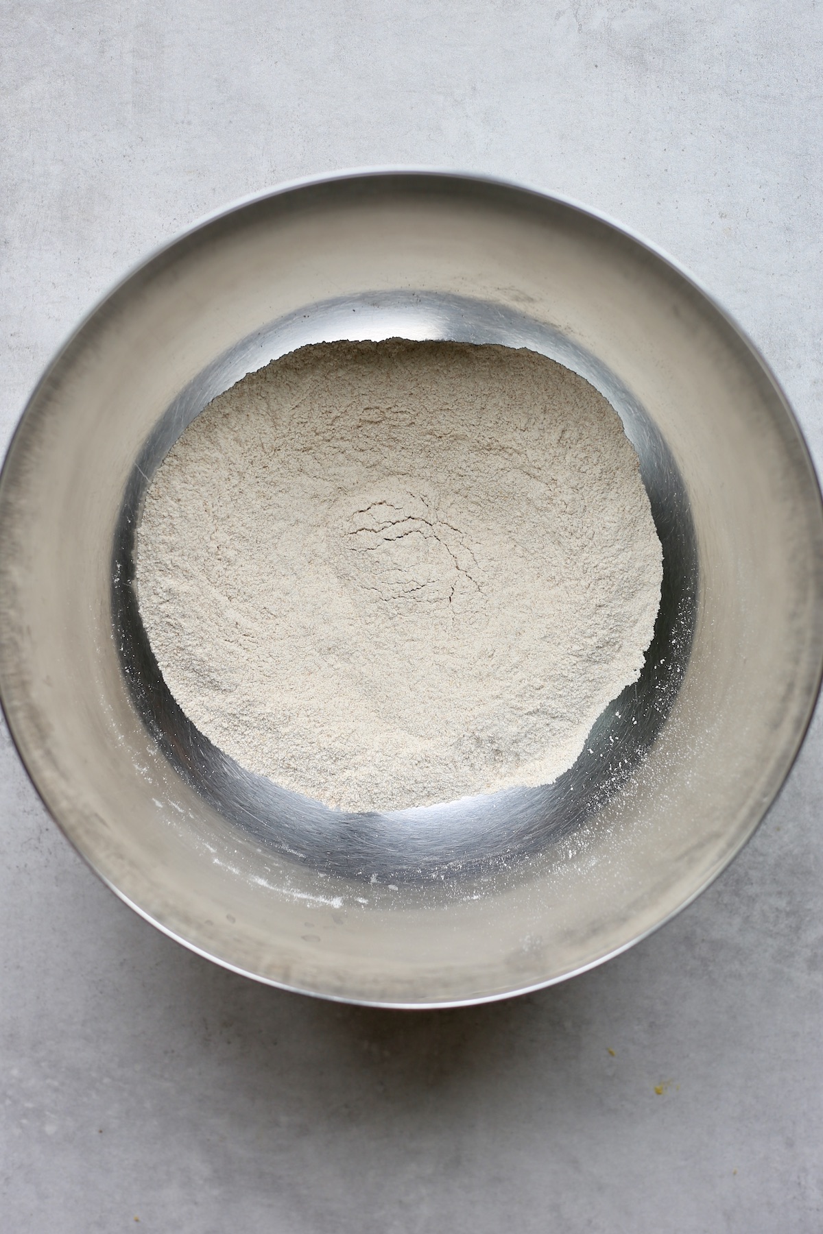 Whole wheat flour, salt, baking powder and baking soda combined in a large silver mixing bowl.